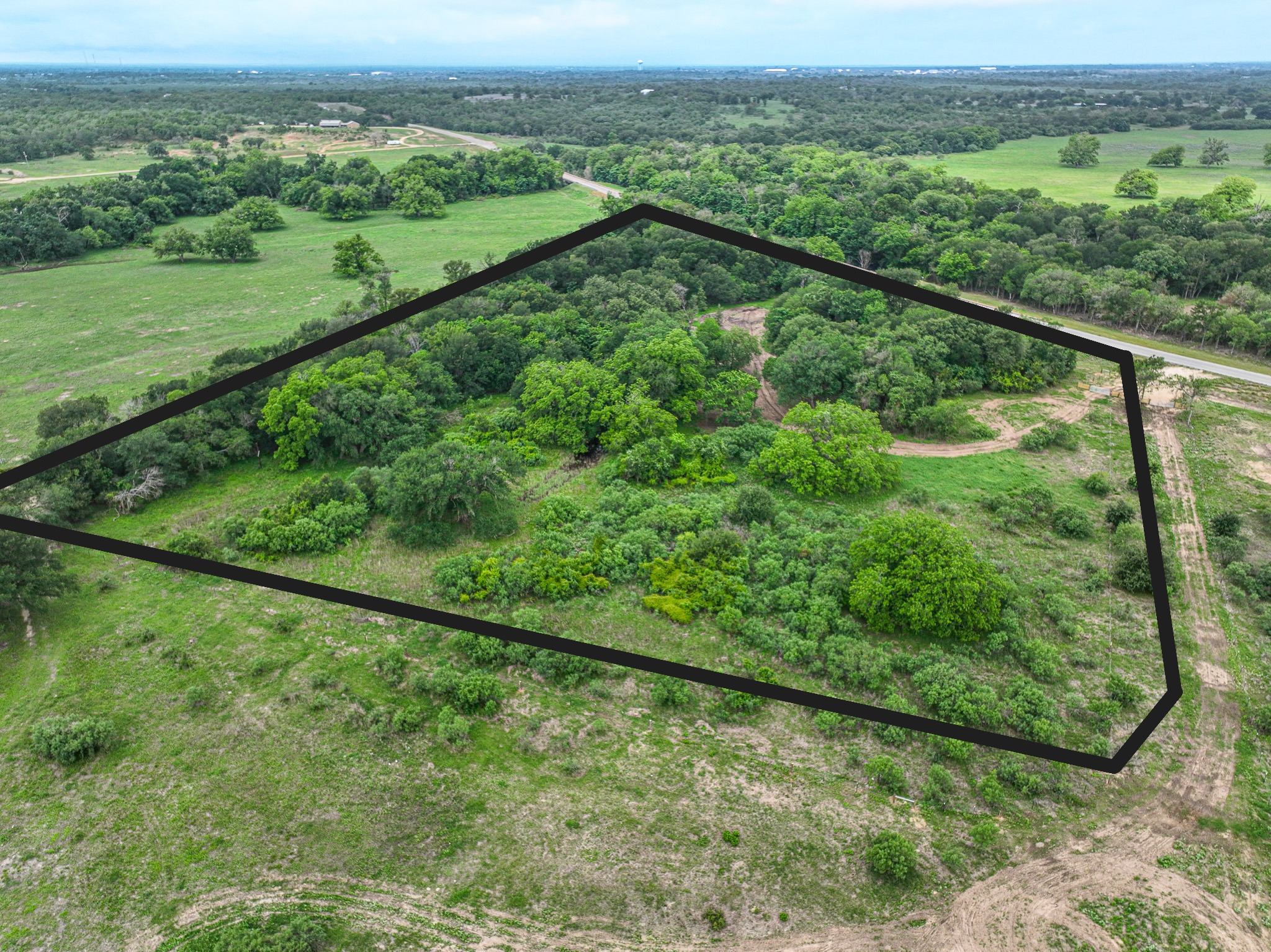Discover a stunning piece of Central Texas landscape located in Luling, TX. This property offers over 12 acres of land, providing the perfect blend of country living and convenience. Enjoy the serene environment, just minutes from town, while experiencing true rural tranquility. The land boasts enormous shade trees and beautiful creek bottom terrain. Its gentle, sloping topography offers pristine views of the surrounding countryside, making it an ideal spot for those seeking scenic vistas. West Plum Creek runs along the backside of the property, adding to its natural appeal. The property features FM highway frontage, ensuring easy access. Several prime building sites are ready for development, with new fencing and electricity already installed. These improvements make the land immediately usable for various purposes. Situated within 5 minutes of Luling and just 10 minutes from Lockhart, this property provides quick access to nearby towns. It is less than an hour from both Austin and San Antonio, and only about 45 minutes from the Austin International Airport and Circuit of the Americas racetrack. 
NO RESTRICTIONS
AG EXEMPT - WILDLIFE
