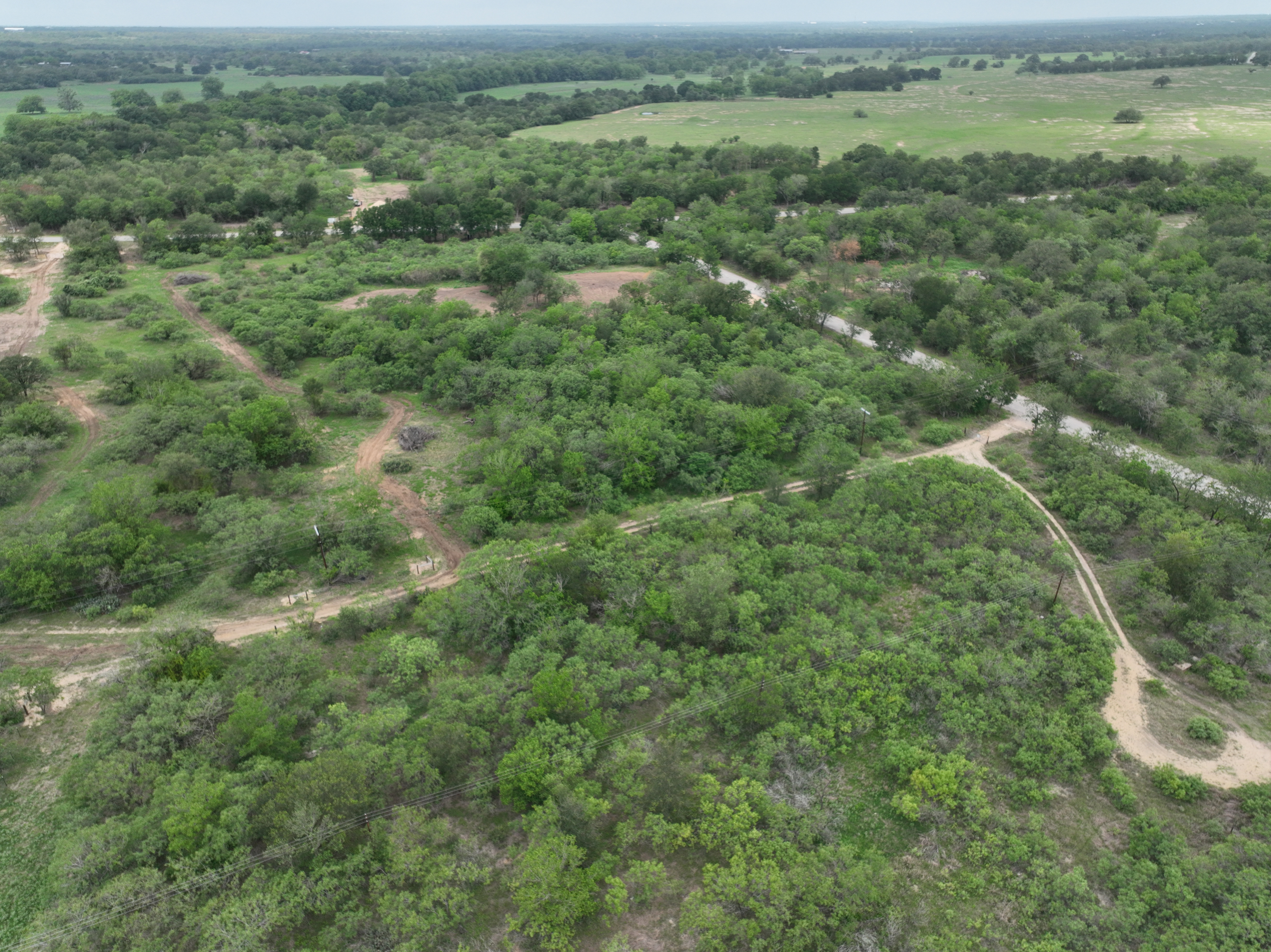 Discover a stunning piece of Central Texas landscape located in Luling, TX. This property offers over 12 acres of land, providing the perfect blend of country living and convenience. Enjoy the serene environment, just minutes from town, while experiencing true rural tranquility. The land boasts enormous shade trees and beautiful creek bottom terrain. Its gentle, sloping topography offers pristine views of the surrounding countryside, making it an ideal spot for those seeking scenic vistas. West Plum Creek runs along the backside of the property, adding to its natural appeal. The property features FM highway frontage, ensuring easy access. Several prime building sites are ready for development, with new fencing and electricity already installed. These improvements make the land immediately usable for various purposes. Situated within 5 minutes of Luling and just 10 minutes from Lockhart, this property provides quick access to nearby towns. It is less than an hour from both Austin and San Antonio, and only about 45 minutes from the Austin International Airport and Circuit of the Americas racetrack. 
NO RESTRICTIONS
AG EXEMPT - WILDLIFE