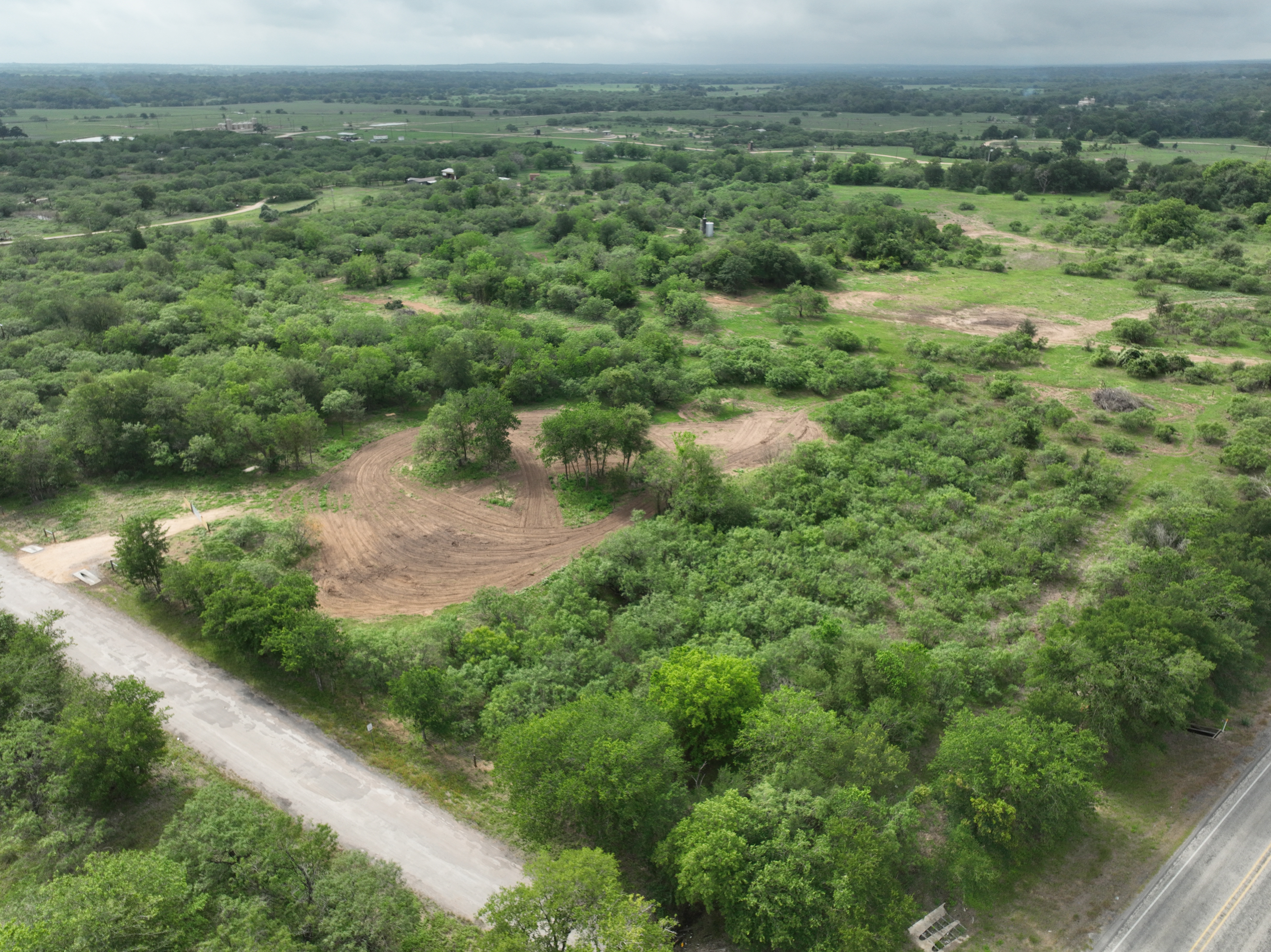 Discover a stunning piece of Central Texas landscape located in Luling, TX. This property offers over 12 acres of land, providing the perfect blend of country living and convenience. Enjoy the serene environment, just minutes from town, while experiencing true rural tranquility. The land boasts enormous shade trees and beautiful creek bottom terrain. Its gentle, sloping topography offers pristine views of the surrounding countryside, making it an ideal spot for those seeking scenic vistas. West Plum Creek runs along the backside of the property, adding to its natural appeal. The property features FM highway frontage, ensuring easy access. Several prime building sites are ready for development, with new fencing and electricity already installed. These improvements make the land immediately usable for various purposes. Situated within 5 minutes of Luling and just 10 minutes from Lockhart, this property provides quick access to nearby towns. It is less than an hour from both Austin and San Antonio, and only about 45 minutes from the Austin International Airport and Circuit of the Americas racetrack. 
NO RESTRICTIONS
AG EXEMPT - WILDLIFE